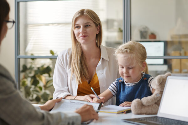A young mother and her toddler at a welfare meeting.