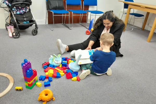 A woman and a child playing with building blocks.